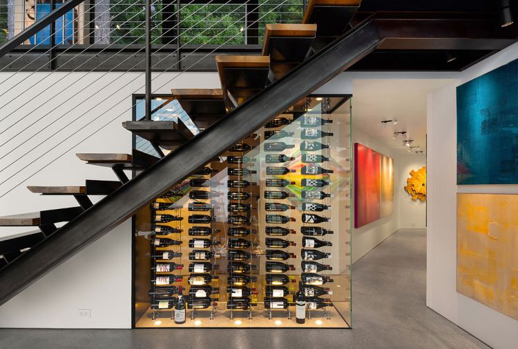 The glass wine display turns vino into art, while the corridor has more wall space to hang art. The artwork in the foreground is from Peri G Fine Art in Palm Springs.