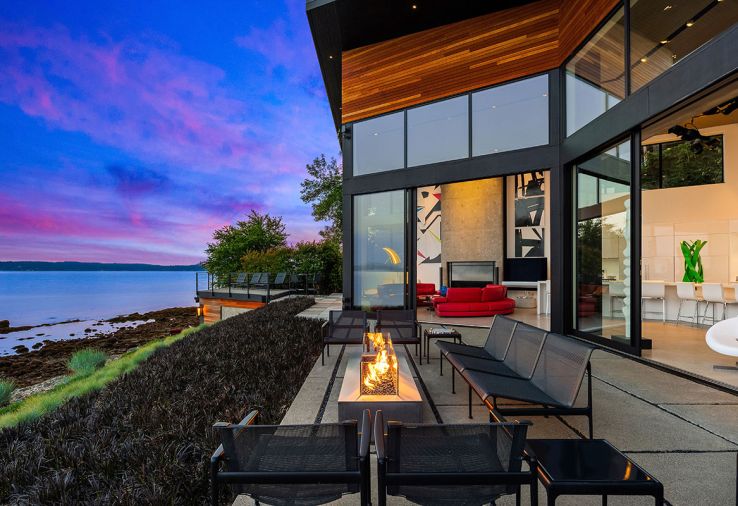 On the patio, a Paloform fireplace is surrounded by outdoor furniture by Richard Schultz from Design Within Reach. “Our favorite thing is that we really experience the weather and the seasons here,” says the owner.