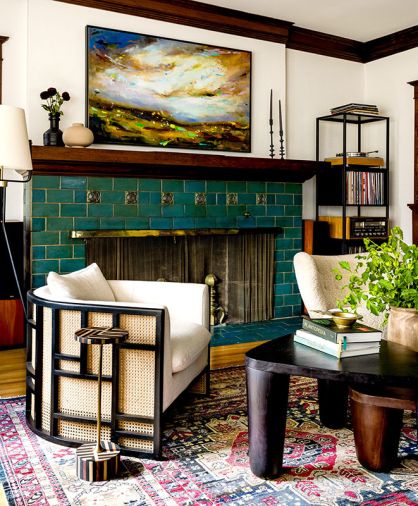 In the living room, a Janna Black Armchair sits with a Trio Nesting Coffee Table from Lulu and Georgia and antique rug from ABC Carpet and Home. Throughout, Benjamin Moore in Atrium White complements the woodwork.