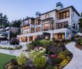 The inspiration to update the exterior using stone pavers from the Dordogne region of France led to facing the terrace with Antique Pearl Merrillstone. Kolbe Windows and Nana Doors, and a custom KODO Unit from Fireside Home Solutions add panache. Lush landscaping by Kenneth Philp Landscape Architects.