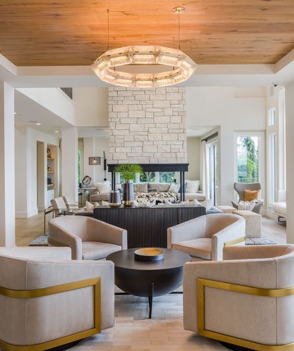 French Domaine “Sully” pavers from Exquisite Surfaces travel from poolside through family room and wine cellar beyond. Como Modular leather sofa from RH is kid-friendly, as is the RH Richards Trunk table. A pair of Tarbell Semi-Flush lighting from Arteriors crowns the room.