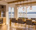 The new dining area overlooks the lake. Briolette Pendants by Gabriel Scott are grounded by French Oak flooring by Chateau Napoleon.