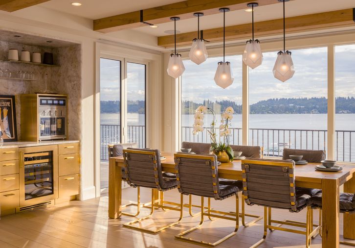 The new dining area overlooks the lake. Briolette Pendants by Gabriel Scott are grounded by French Oak flooring by Chateau Napoleon.
