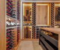 Beyond the family room is the wine room with Winterwood Custom Cabinetry paired with metal dowels and shelving from Charles Hidalgo.