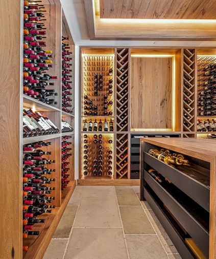 Beyond the family room is the wine room with Winterwood Custom Cabinetry paired with metal dowels and shelving from Charles Hidalgo.