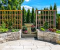 In a throwaway streetside space, Kenneth Philp Landscape Architects created an organic herb, vegetable and cutting garden set against sculptural wood trellises, an elegant stone fountain and a bank of arborvitae.