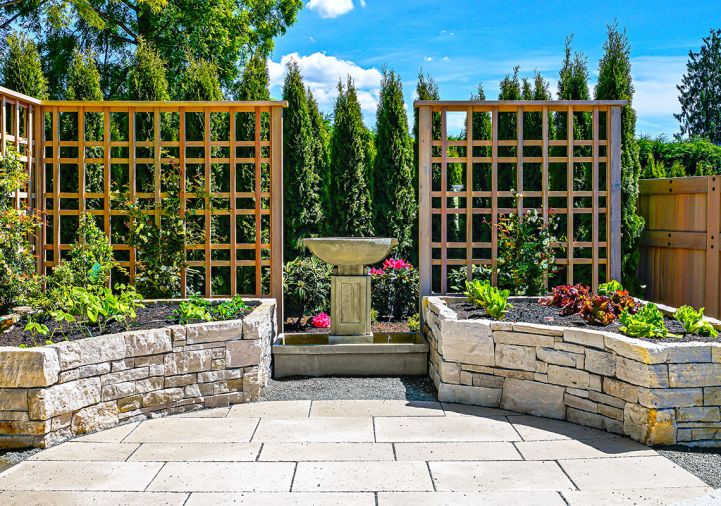 In a throwaway streetside space, Kenneth Philp Landscape Architects created an organic herb, vegetable and cutting garden set against sculptural wood trellises, an elegant stone fountain and a bank of arborvitae.