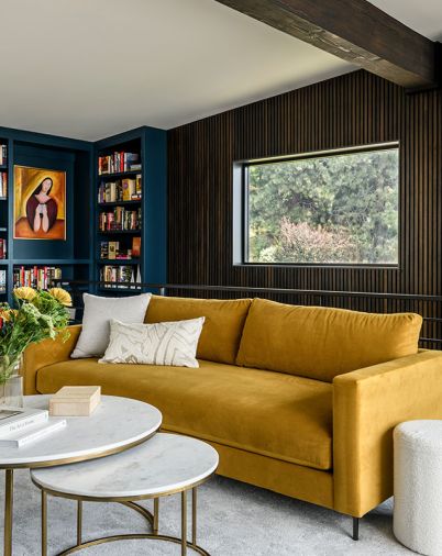 The Jake Sofa offers a pop of color in the library along with shelves painted in Benjamin Moore’s “Twilight”. The custom wood paneling and shelving by Smith Custom Woodworking create a comfortable space to read