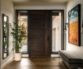 Welcoming guests, Hammerton Studio sconces flank a painting that recalls local trees in autumn and large windows throughout offer views of inspiration. The interior designer pulled in many elements of the natural environment into the design