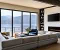 A generous hearth is fashioned from leathered granite and provides additional seating to the Miranda sectional from Room & Board. The fireplace is framed in Porcelanosa Japan Blanco tile and the coffee table and Remy Chair are both from Pottery Barn
