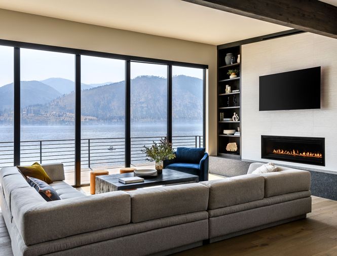 A generous hearth is fashioned from leathered granite and provides additional seating to the Miranda sectional from Room & Board. The fireplace is framed in Porcelanosa Japan Blanco tile and the coffee table and Remy Chair are both from Pottery Barn