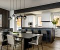 The dining room’s wood accent wall ties with the library wall paneling. The classic look of a table built by Smith Custom Woodworking sync with the kitchen’s Chloe tile backsplash and blue hues in the Ijen Blue Quarzite counters