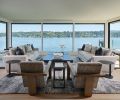 The family room gets an undisrupted water view amidst cozy sofas by A. Rudin from Trammell Gagné and tables from Shoenfeld Interiors.