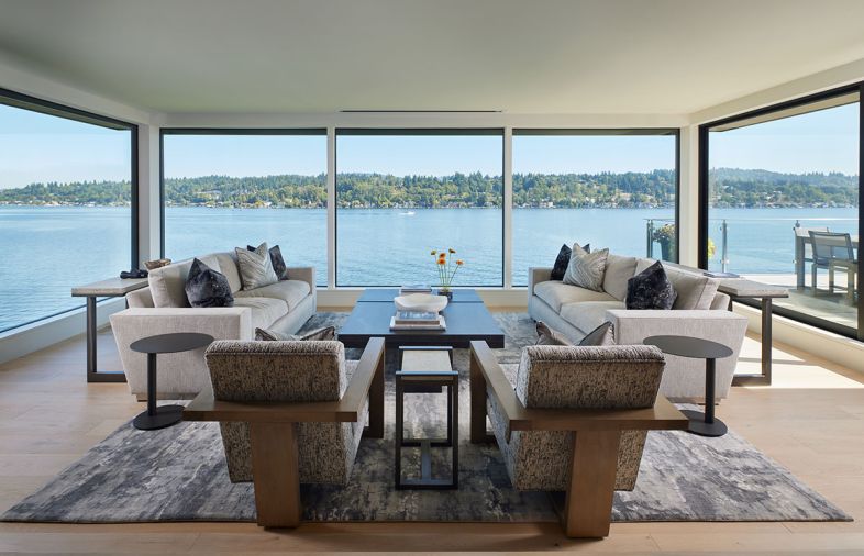 The family room gets an undisrupted water view amidst cozy sofas by A. Rudin from Trammell Gagné and tables from Shoenfeld Interiors.