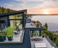 The home’s handsome black exterior contrasts perfectly against the decks’ porcelain pavers. The newly elevated primary suite’s roof slants dramatically toward the sunset.