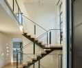 March and his metal fabricator designed and engineered the complex steel staircase. The entry door with auto closer features three white oak wood panels that are each 11 feet tall and stained dark. An electronic keypad lives on the outside wall.