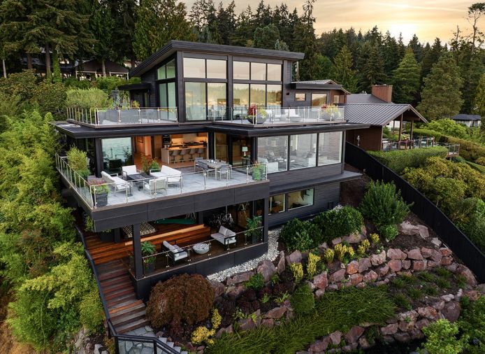 The newly remodeled home perches high above the water, with its four decks enjoying waterside views. Comfortable outdoor furnishings and fire features from RH are found on three of them.
