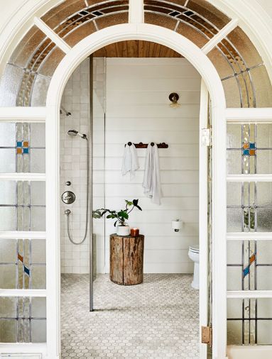 Anne wisely showcased the stunning salvaged stained-glass door discovered at Bloomsbury Art & Fine Antiques for the primary bath’s entry. “Milk Mustache” paint by Dunn Edwards echoes the door’s trim, while Ann Sacks Carrara hex tile grounds the room.