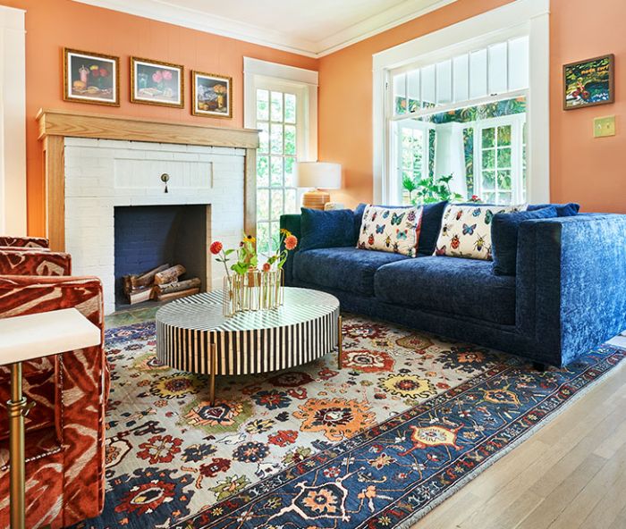 Happy, rich colors enrobe the living room’s walls and furnishings revolving around a multicolored rug.