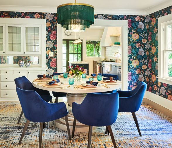 Florals found in Cole & Son “Midsummer Bloom” wallpaper encircle the dining experience crowned by a fabulous Regina Andrew Cabaret Fringe chandelier, circular CFC Liz dining table and voluptuous velour chairs.