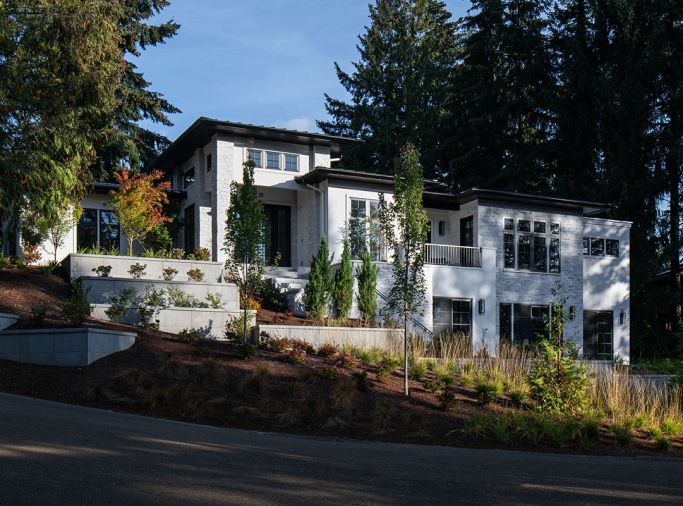 The exterior is painted in Sherwin Williams “Snowbound” with trim in “Tricorn Black,” and paired with white masonry accents. A black roof and ample windows create the rest of the look.