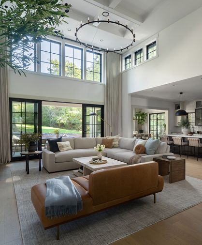 Four Hands side tables from J Garner Home flank the Restoration Hardware sectional. A leather sofa from Interior Define is an artful spot to lounge or seat guests.