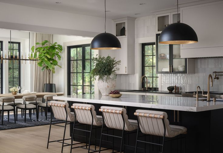 Finishes include brushed oak floors and a porcelain island counter, joined with white leather counter stools from Denver Modern. Bedrosians Cloe tile and Eglo pendant lights bring sheen to the kitchen.