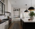 Entertaining is made easy with an open floor plan offering clear views of the dining and living room. The two-tone kitchen has cabinetry from LCM Cabinets, painted in “Agreeable Gray” and “Tricorn Black”.