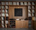 Walnut shelving and cabinetry in the office is crafted by Northwest Custom Cabinets, to house the homeowner’s extensive record collection. A brass RH sconce highlights artwork by Erin Sullivan.