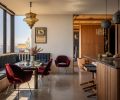 Overlooking the Puget Sound, the banquette has upholstery covered in Knoll Textiles, combined with Eero Saarinen chairs and a Le Corbusier table. A La Scala pendant from MR hangs overhead.
