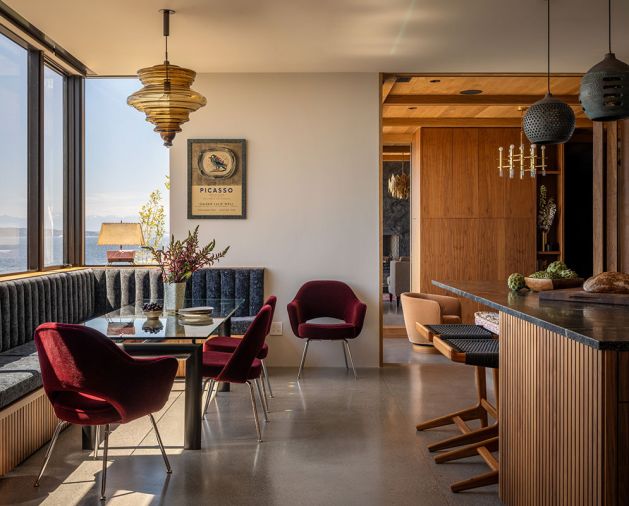 Overlooking the Puget Sound, the banquette has upholstery covered in Knoll Textiles, combined with Eero Saarinen chairs and a Le Corbusier table. A La Scala pendant from MR hangs overhead.