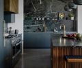 A soapstone counter and back splash from Crocodile Rocks is found in the kitchen, paired with cabinets painted in Farrow & Ball “Studio Green” and pendant lights from Heather Levine Ceramics.