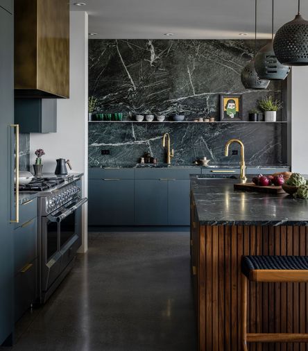 A soapstone counter and back splash from Crocodile Rocks is found in the kitchen, paired with cabinets painted in Farrow & Ball “Studio Green” and pendant lights from Heather Levine Ceramics.