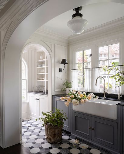 The pass-through pantry connects to the kitchen with custom marble tile flooring designed by Lawton and made by New Ravenna, complemented by a Black Mist Granite honed counter. Dual dishwashers flank the Shaws sink to make for a very pretty and very hardworking area.