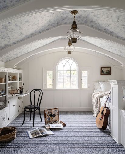 In the attic “Peter Pan Room,” the Nourison carpeting syncs with the ceiling’s map from York Wallcoverings. The preserved built-ins and reconstructed ceiling ribs are all painted in Benjamin Moore “White Dove.”