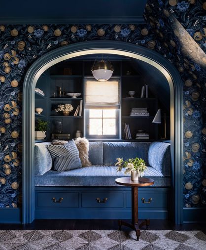 In the upper-floor library, Zak+Fox Orangerie wallcovering surrounds a reading nook full of comfy cushions upholstered in Kravet Couture fabric.