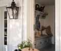 A Colonial lamp illuminates the door to the mudroom, which has Sonoma Tile Makers chevron flooring and a custom bench and coat rack from Northwest Custom Cabinets.