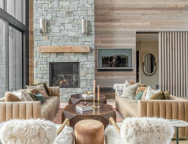 The Art Deco vibe is carried throughout the great room with bold Arhaus coffee tables flanked by Four Hands leather sofas and wall paneling to mirror the exterior siding.