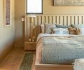 The custom bedframe with integrated nightstands for the couple’s nine-foot-wide mattress was designed by Shannon, so the whole family and two dogs can pile in at once. Sherwin Williams “Rookwood Clay” dresses the walls.