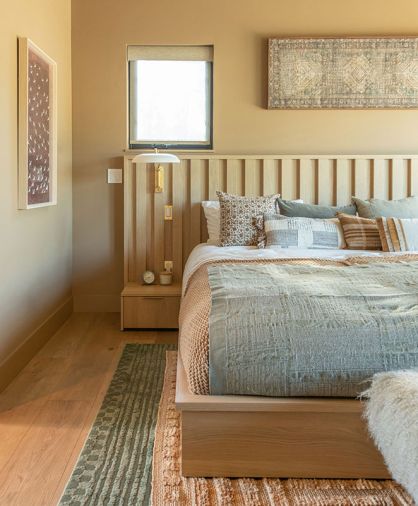 The custom bedframe with integrated nightstands for the couple’s nine-foot-wide mattress was designed by Shannon, so the whole family and two dogs can pile in at once. Sherwin Williams “Rookwood Clay” dresses the walls.
