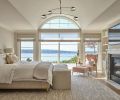 The primary suite beckons with the promise of a comfy king bed and lounge chair easily pulled up before the rebuilt fireplace and surround.