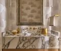 Guests are greeted with a stellar jewel box powder room whose dreamy aspects include a Calacatta Viola marble sink by Lambert Stoneworks, with ceruse finish cabinet by O.B. Williams and Morgans Fine Finishes.