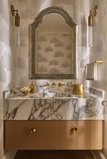 Guests are greeted with a stellar jewel box powder room whose dreamy aspects include a Calacatta Viola marble sink by Lambert Stoneworks, with ceruse finish cabinet by O.B. Williams and Morgans Fine Finishes.