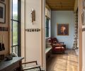 The hallway provides space for the owners’ multifaceted collection of art and antiques. Large windows allow for prairie views and ample natural light.