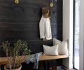 The new entry displays a pre-stained and reclaimed wooden accent wall with a custom wooden bench from Three Creeks Woodworking.