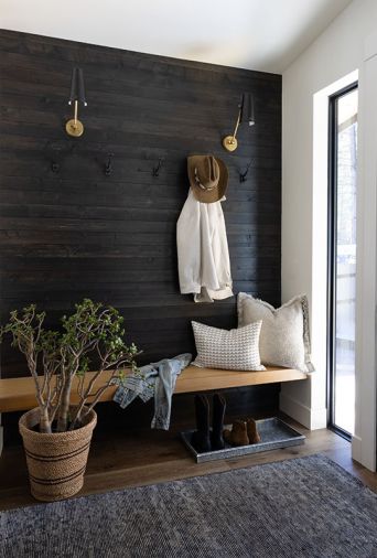 The new entry displays a pre-stained and reclaimed wooden accent wall with a custom wooden bench from Three Creeks Woodworking.