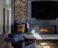 The fireplace has an industrial feel, which sets it apart from the white walls and wood cladding. The metalwork was done by Devotion Industries, the sling chair is from Four Hands.