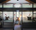 In the bunk room, the custom bunks are designed by Olin Architecture and built by Dyer Construction, with sconces and quilts from Schoolhouse Portland.