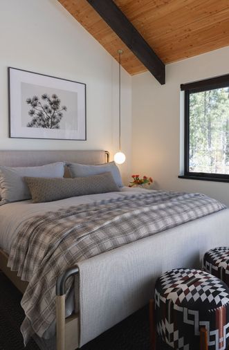 Benjamin Moore “White Dove” paint is used throughout, including in the primary suite, with an upholstered and steel bed from Four Hands and stools recovered in Pendleton fabric.
