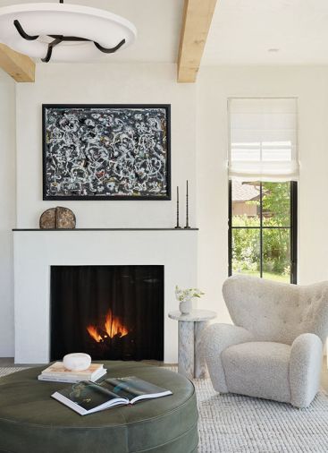 The library is warmed by a Sutter Home & Hearth, Town and Country fireplace with Alden Mason artwork masking the TV.